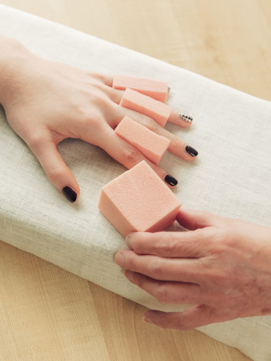 Eine Hand während der Behandlung mit Schaumstoffblöcken